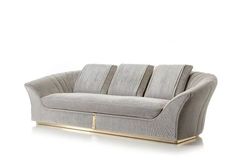 a gray couch with gold legs on a white background