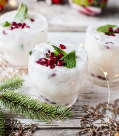 two glasses filled with ice and garnished with pomegranates on a wooden table