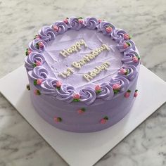 a purple birthday cake on a white plate