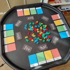 a board game with letters and numbers arranged in the middle on a black table top