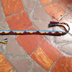 a multicolored rope with tassels is laying on the ground