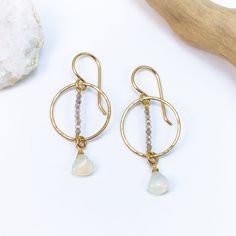 The Opal Twilight Earrings feature delicate hoops crafted from high-quality gold-filled material, symbolizing the elegance of a twilight sky. The hoops are adorned with tiny shimmering labradorite gemstones, reminiscent of the stars that twinkle during the evening hours. These labradorite gems, with their iridescent play of colors, add a touch of celestial magic to the design. Suspended below, is the focal point of these earrings: a genuine Ethiopian opal. Its captivating play of colors, ranging Twilight Earrings, Celestial Magic, Twilight Sky, Jewelry Repair, Ethiopian Opal, Semi Precious Gemstones, Twinkle Twinkle, Focal Point, Labradorite