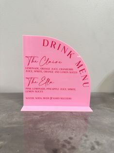 a pink drink menu holder sitting on top of a table