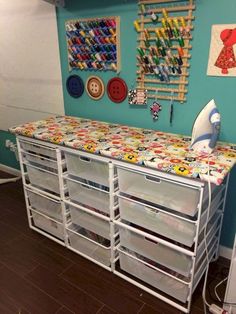 an ironing board with lots of buttons on it and plastic bins under the drawers