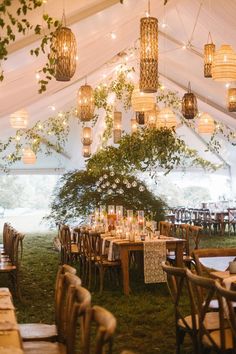 the inside of a tent with tables and chairs set up for an outdoor wedding reception