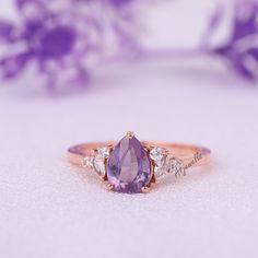 a close up view of a ring with an oval shaped stone surrounded by smaller stones