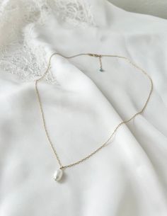 The perfect something blue gift!  A beautiful dainty freshwater pearl necklace with a subtle something blue.  Can be worn on the wedding day or as an every day necklace to remind the bride of that special day! Each necklace is handmade to order in the USA Fully adjustable - just slide the gold/silver ball along the necklace to achieve the desired length 14k Gold filled or Sterling Silver AAA Quality Genuine Freshwater Pearl, natural white color 8x11mm 4mm Swarovski Crystal pearl at the end of each necklace  Total length: 20 inches - fully adjustable to any length under 20 inches *custom sizes available upon request All orders come beautifully packaged and ready to gift for free! Matching bracelet and earrings available Bracelet: https://www.etsy.com/listing/1344949081/ Earrings: https://ww Something Blue Necklace, Delicate Teardrop Birthstone Necklace, Delicate Birthstone Necklace With Teardrop Pendant, Delicate Pearl Pendant Charm Necklace, Delicate Birthstone Charm Necklaces For Weddings, Pearl Necklace For Bridesmaid Gift, Delicate Teardrop Pearl Charm Necklace, White Charm Necklace With Birthstone For Wedding, Delicate Single Strand Bridal Necklace As Gift