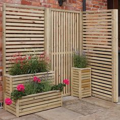 three wooden planters sitting next to each other in front of a brick building