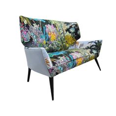 an upholstered chair with colorful flowers and plants on it