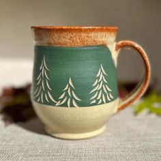 a green and white coffee cup sitting on top of a table