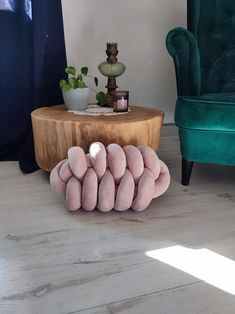 a group of pillows sitting on top of a wooden table next to a green chair