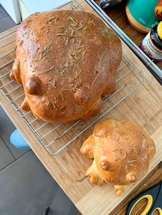 a loaf of bread sitting on top of a wooden cutting board next to another loaf of bread