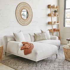 a living room with a white couch and some baskets on the floor next to it