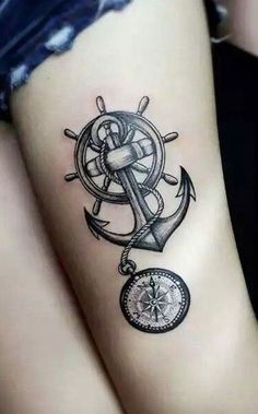 an anchor, compass and steering wheel tattoo on the side of a woman's leg