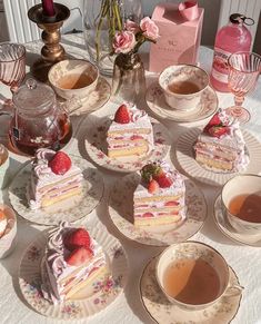 a table topped with lots of cakes and cups of tea next to each other on plates