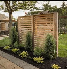 a wooden fence in the middle of a yard