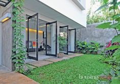 an outside view of a house with plants growing on the side of it and glass doors