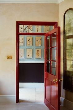 an open door leading to a room with paintings on the wall and a mirror above it