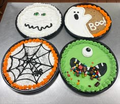 four decorated halloween cakes sitting on top of a table