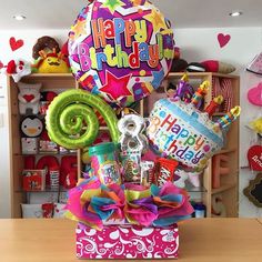 a birthday gift box filled with balloons, candy and other items for someone's special occasion