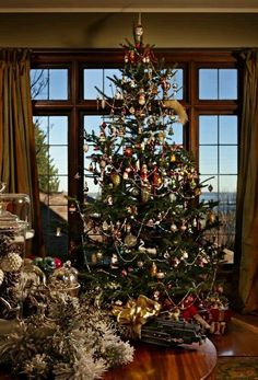 a decorated christmas tree sitting in front of a window