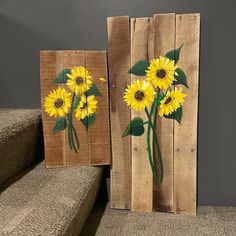 two pieces of wood with sunflowers painted on them sitting next to each other