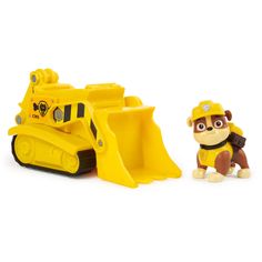 a yellow toy bulldozer next to a small plastic dog in front of it