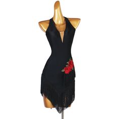 a mannequin wearing a black dress with red roses on the back and fringe