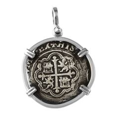 a silver pendant with an image of a cross on it