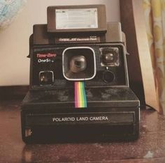 an old polaroid camera sitting on top of a table