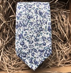 The Blue Scheherazade Floral Necktie in Cotton. This is a blue floral men's tie - perfect for weddings. We offer free shipping within the UK or a standard  WorldWide shipping cost of £3.99 to all countries outside of the UK. We also offer a free handwritten gift tag service - just leave the wording that you would like on the gift tag in the notes from buyer.  If you choose 'gift wrapping' we will send your item beautifully wrapped in a cardboard box with string and a gift tag with your message. We can also make all of our ties in children's sizes. Dimensions of tie: Tie width: 6cm   Tie length: 147cm   Also available in 8cm wide tie We offer a set of pre-made ties and pocket squares. The full set comprises of a bow tie, necktie and pocket square or each item can be bought individually. Our Blue Ties For Wedding Neckwear, Blue Wedding Neckwear With Ties, Dapper Blue Standard Tie, Blue Tie For Black Tie Event And Father's Day, Blue Standard Tie For Father's Day, Blue Standard Tie For Wedding, Dapper Blue Wedding Ties, Blue Ties For Father's Day, Blue Suit And Tie Accessories For Wedding