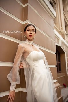 a woman in a wedding dress leaning against a wall