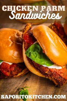 two chicken parm sandwiches with lettuce and tomato sauce on the buns