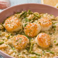 a bowl filled with rice and scallops on top of a blue table cloth