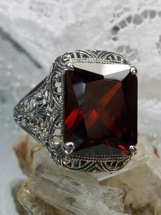 Garnet Cubic Zirconia (CZ) Ring Autumn Design #D200 Inspired by Victorian era designs, this lovely filigree reproduction has been recreated in sterling silver. This flawless 5 carat red garnet cubic zirconia gemstone is 12mm x10mm in size. The ring sits 17mm (11/16") North to South on the finger. The inside of the band is etched 925 for sterling silver. Notice the intricate and detailed design of the antique silver filigree setting all the way down the band. This is an exquisite rendition of an Elegant Rectangular Ruby Ring For Formal Occasions, Classic Ruby Ring With Rectangular Stone For Anniversary, Formal Rectangular Garnet Rings, Elegant Square Cut Ruby Ring For Formal Occasions, Classic Octagon Ruby Ring For Gift, Rectangular Garnet Rings In Elegant Style, Elegant Garnet Rings In Rectangular Shape, Classic Rectangular Ruby Ring, Elegant Rectangular Garnet Rings