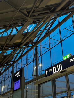 an airport terminal with glass walls and signs