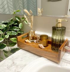 a wooden tray with soap, lotion and other items on it in front of a mirror