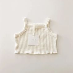 This beautiful summertime crop tank is one of our favorite pieces for summer. Paired with the matching ribbed shorts this dreamy vintage stripe pattern set is the perfect capsule outfit. The shape, the soft ribbed cotton, the color, everything about this tank is something to love. Ethically made Made of: 95% Premium Ribbed Cotton, 5% Spandex Care: Wash Cold, Gentle Cycle, Dry Flat Summer Striped Ribbed Tops, Striped Ribbed Cotton Tank Top, Everyday Ribbed Cotton Crop Top, Beige Tops For Summer Playwear, Beige Ribbed Cotton Tank Top, Cute Beige Loungewear Top, Cute Beige Tops For Loungewear, Spring Cotton Ribbed Crop Top, Spring Ribbed Cotton Crop Top