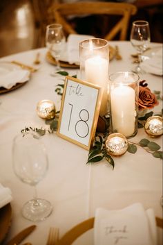 the table is set with candles and place cards