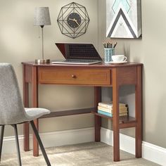 a wooden desk with a laptop computer on top of it next to a gray chair