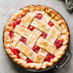 a close up of a pie in a pan on a table with utensils