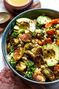 a blue bowl filled with vegetables and bread