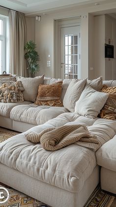 a living room filled with lots of furniture and pillows on top of a rug covered floor