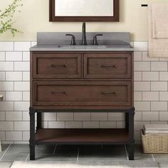 a bathroom vanity with two drawers and a mirror above it, in front of a white tiled wall