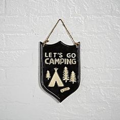 a sign that says let's go camping hanging on the wall