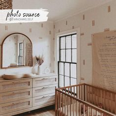 a baby's room with a crib, dresser and mirror on the wall