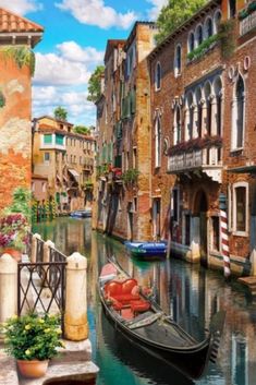 a painting of a boat on a canal in venice, italy with buildings and flowers