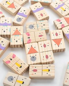 several wooden blocks with different shapes and sizes are arranged on a white surface in the shape of animals