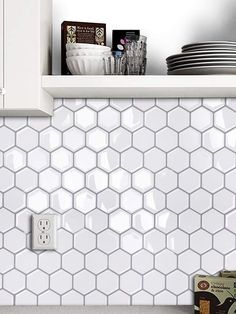 a kitchen with white hexagonal tiles on the backsplash