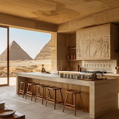 a kitchen with an island counter and stools in front of the pyramids